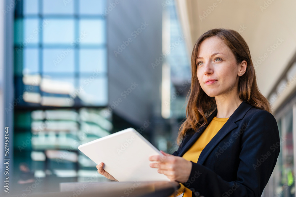 Contemplative businesswoman holding tablet PC Contemplative businesswoman holding tablet PC