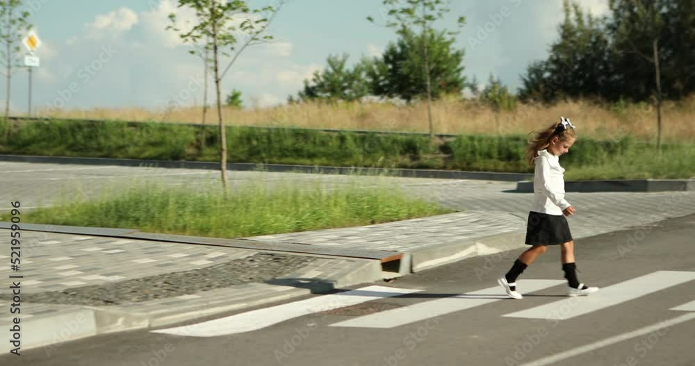 schoolgirl crosses the road at a pedestrian crossing schoolgirl crosses the road at a pedestrian crossing