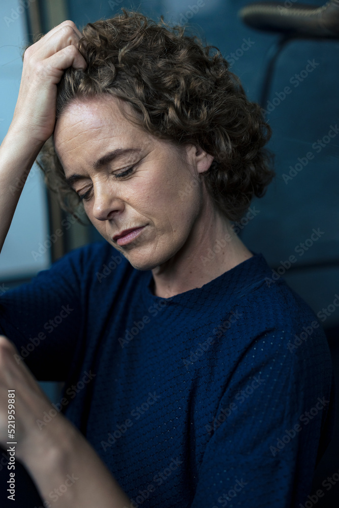Stressed businesswoman sitting with hand in hair Stressed businesswoman sitting with hand in hair