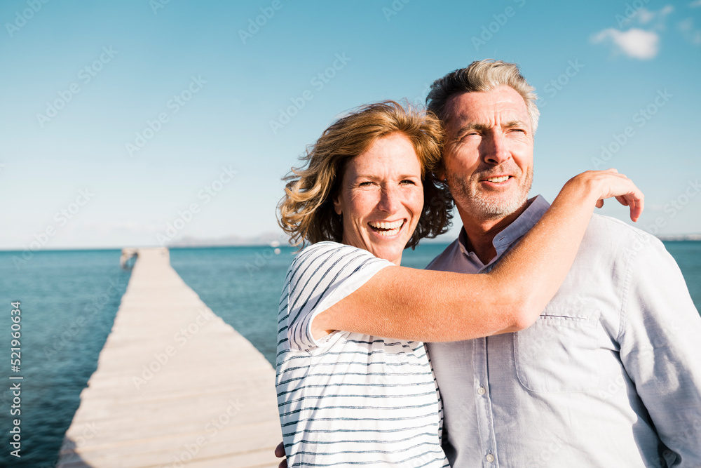 Happy mature woman and man standing on jetty Happy mature woman and man standing on jetty