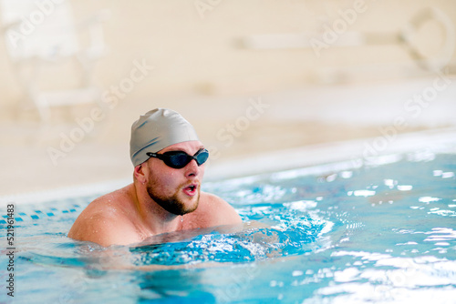 Fat man in the swimming pool.  Sports exercises