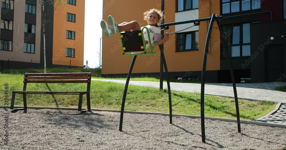 little girl ride on a swing in the playground