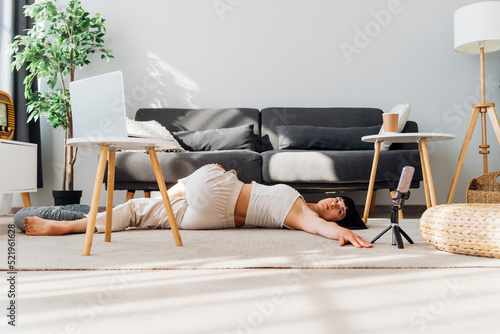 Woman practicing supine spinal twist at home photo