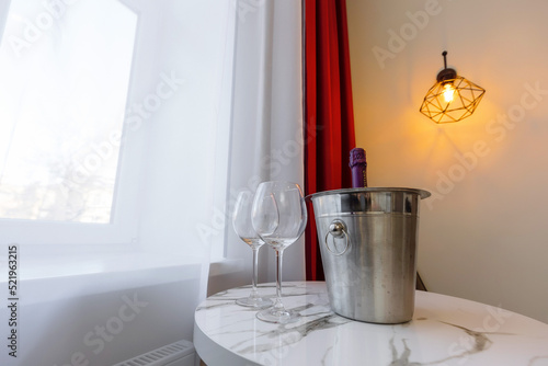 two glass goblets and champagne in a bucket on the table. dating preparation. Good way to pass the evening