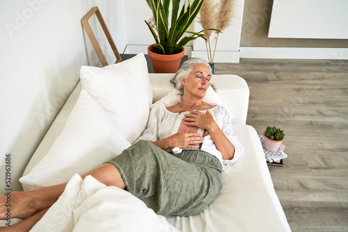 Woman with book napping on sofa at home