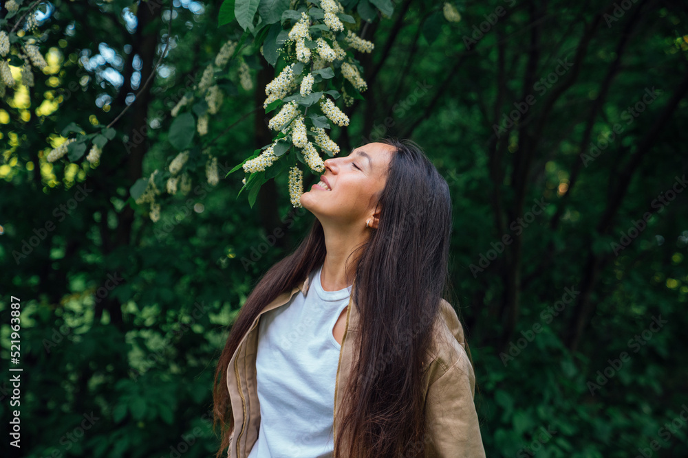 Happy woman smelling blossoms at park Happy woman smelling blossoms at park