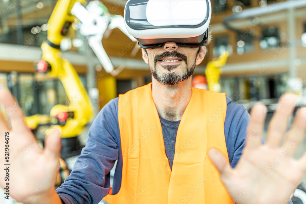 Industrial worker in robotics factory using virtual reality simulator Industrial worker in robotics factory using virtual reality simulator