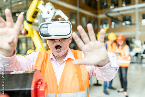 Industrial worker in robotics factory using virtual reality simulator