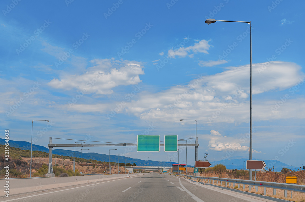 Clear high way with green road sign and blue beautiful cloudy sky