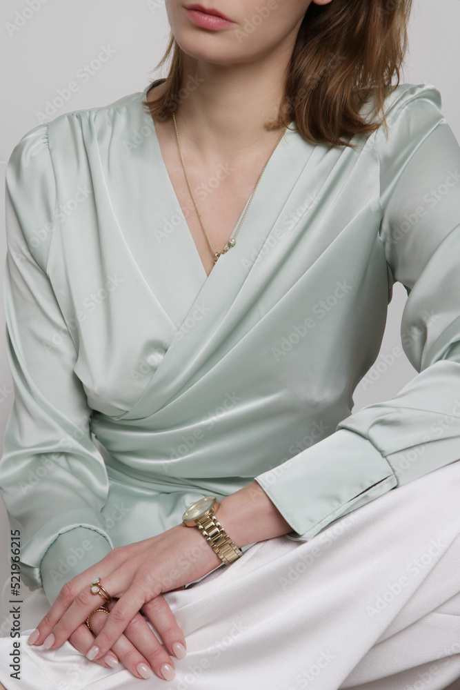 Serie of studio photos of young female model wearingmint green silk satin wrap blouse	