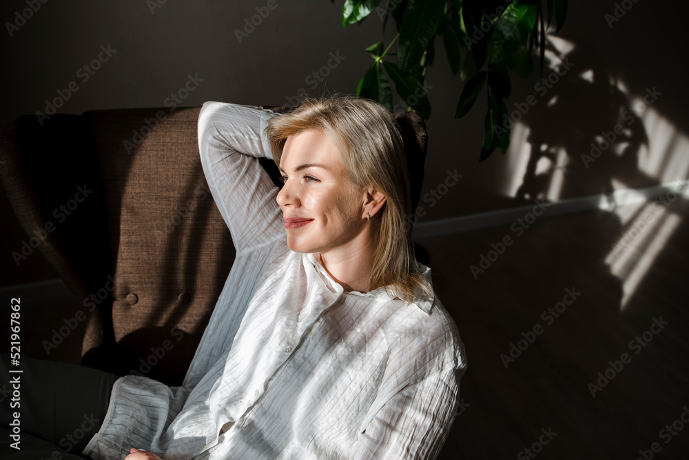 Smiling woman relaxing with hands behind head at home Smiling woman relaxing with hands behind head at home
