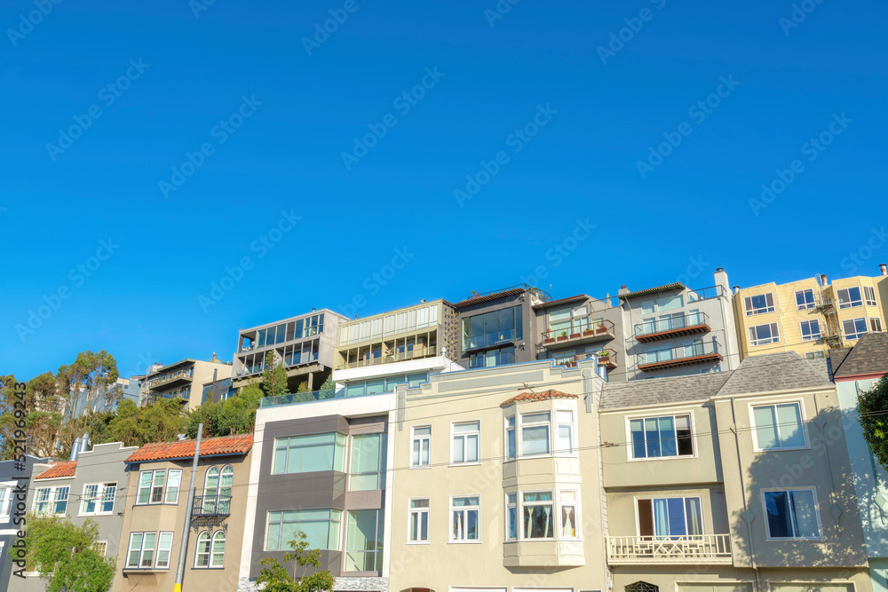 Fototapeta premium Urban houses in San Francisco, California against the clear blue sky background
