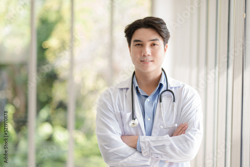 Asian doctor man portrait in professional uniform standing with smile and confidence.