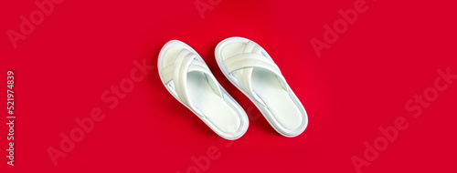 Women's summer white slippers on a red background. Slippers. Banner for insertion into site. Place for text cope space. Horizontal image