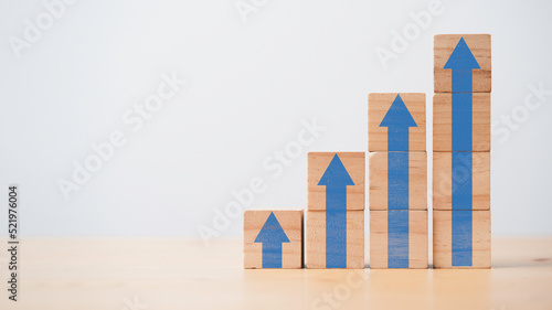 Increasing of blue up arrow on wooden cube block with copy space for business investment growth and career path success concept.