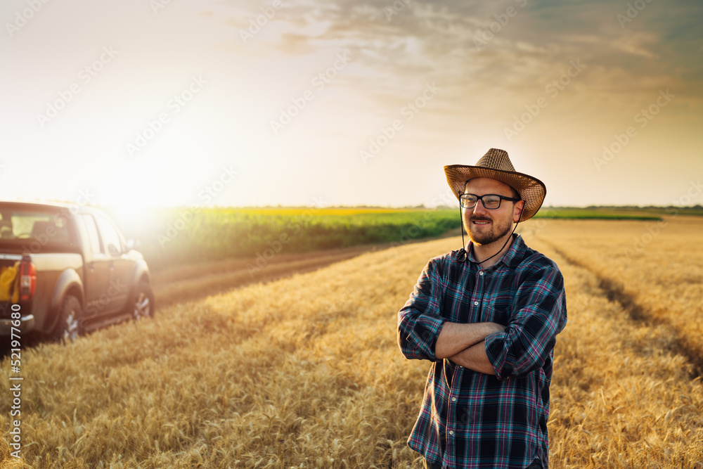 caucasian farmer standing crossed arms in wheat field