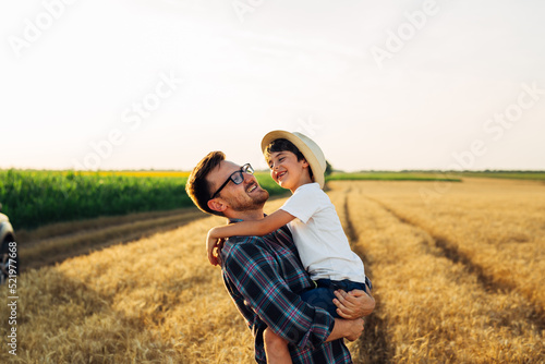 father and son in wheat field. father holding his son