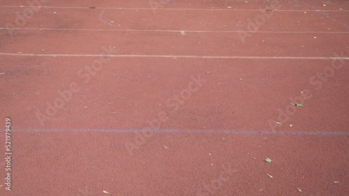 Basketball ball rolls through outdoor red street court