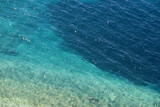 Transparent sea surface with light stones on a bottom. Summer beach, turquoise water for background