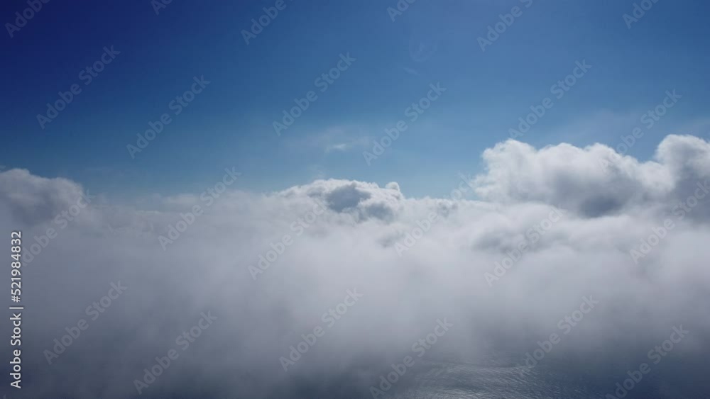Aerial view. The drone flies over foggy and fluffy clouds. Blue sky sun and sea fog. Abstract aerial nature summer ocean sunset sea and sky background. Vacation, travel and holiday concept Aerial view. The drone flies over foggy and fluffy clouds. Blue sky sun and sea fog. Abstract aerial nature summer ocean sunset sea and sky background. Vacation, travel and holiday concept