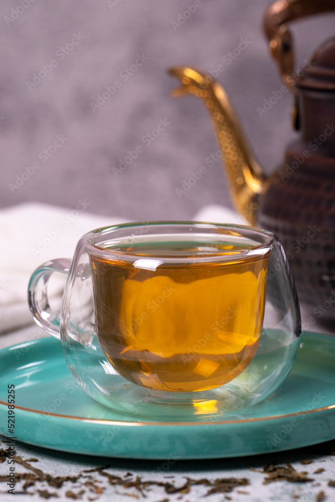 Green tea. Green tea brewed with copper teapot on stone background. Healthy drinks. Herbal tea concept. close up Green tea. Green tea brewed with copper teapot on stone background. Healthy drinks. Herbal tea concept. close up