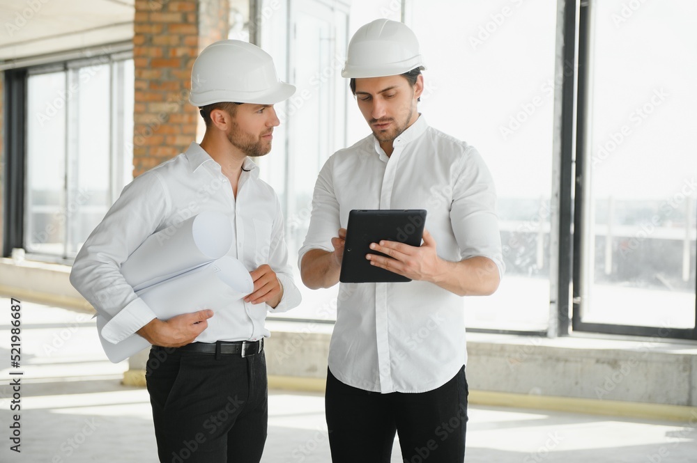Two Specialists Inspect Commercial, Industrial Building Construction Site. Real Estate Project with Civil Engineer Two Specialists Inspect Commercial, Industrial Building Construction Site. Real Estate Project with Civil Engineer