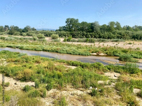 Tordera River is born in the Montseny and flows into the Mediterranean Sea. Rivers of Catalonia, Spain. River with green trees in the background. photo