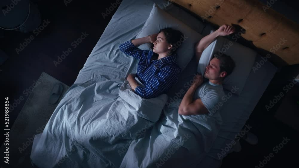 Top View Apartment: Happy Young Couple Side Cuddling Together in the Bed Sleeping at Night. Beautiful Girlfriend and Handsome Boyfriend Sleeping Together. Family of two Sweetly Embracing Each other Top View Apartment: Happy Young Couple Side Cuddling Together in the Bed Sleeping at Night. Beautiful Girlfriend and Handsome Boyfriend Sleeping Together. Family of two Sweetly Embracing Each other