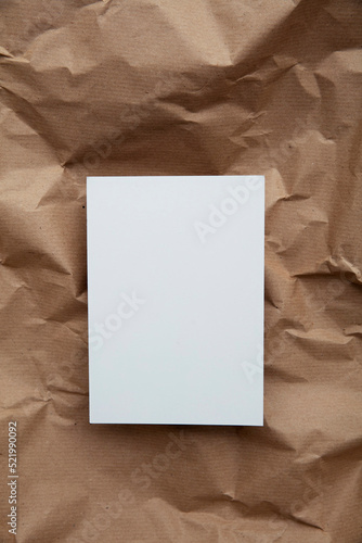 Blank white invitation letter template mock up on crumpled brown paper