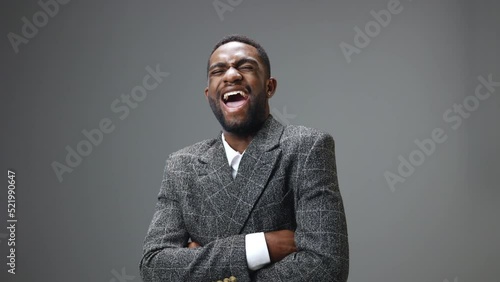 African american business man laughs hard and cackles on a gray background in the studio. Close-up slow motion video