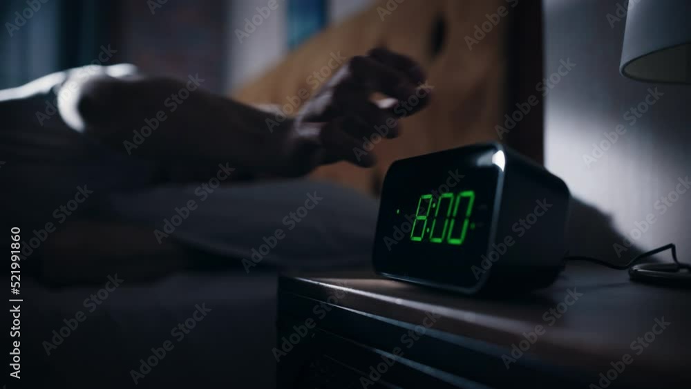 Man Wakes Up and Turns off Alarm Clock. Early Rising Productive Man Ready Start a Day of New Business Opportunities. Focus on the Clock Showing Eight O'Clock on Bedside Nightstand bedroom Apartment