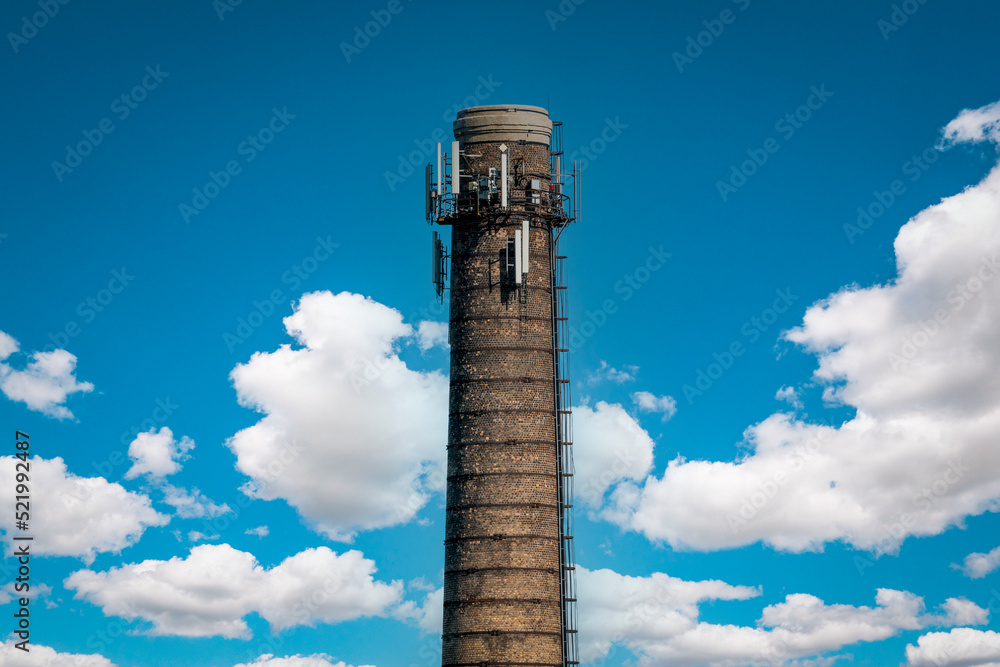 Chimney of a thermal power plant of a boiler room heating against a  sky background