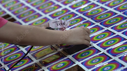 Child holding a hammer knocking a hole to win a surprise prize at famous Taiwan night market, traditional childhood game, close up shot. photo