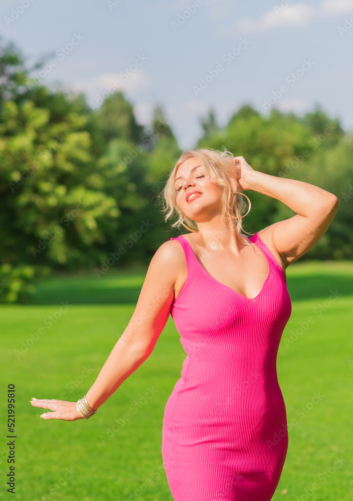Plus size American blonde woman in pink midi dress at nature. Life of people xl size, happy nice natural beauty woman Plus size American blonde woman in pink midi dress at nature. Life of people xl size, happy nice natural beauty woman