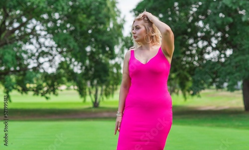 Plus size American blonde woman in pink midi dress at nature. Life of people xl size, happy nice natural beauty woman © T.Den_Team