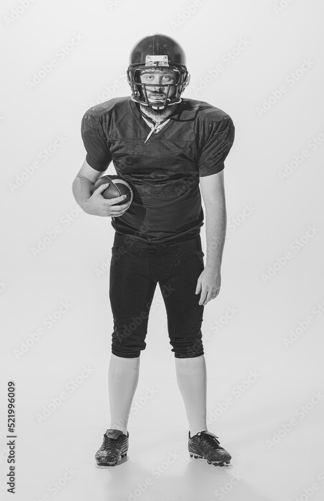Black and white portrait of american football player in vintage style sports uniform isolated on white background. Monochrome