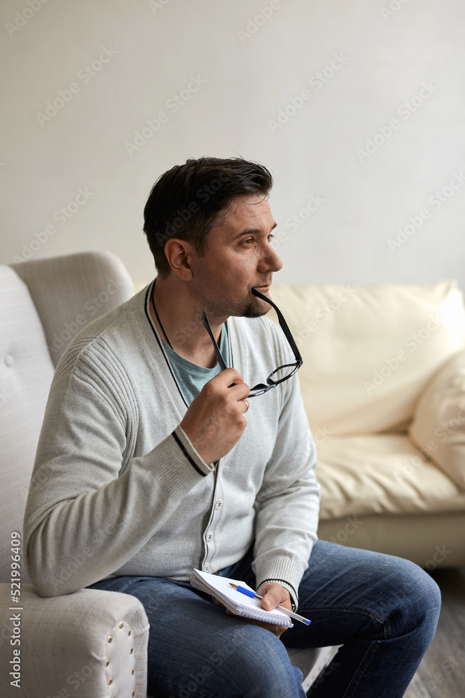 Friendly psychologist with clipboard, leaning at wall in office, empty space Friendly psychologist with clipboard, leaning at wall in office, empty space