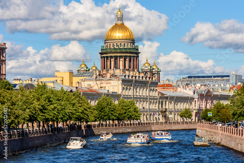 St. Isaac's cathedral and cruise boats on Moyka river, Saint Petersburg, Russia