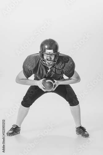 Black and white portrait of american football player in vintage style sports uniform isolated on white background. Monochrome © master1305