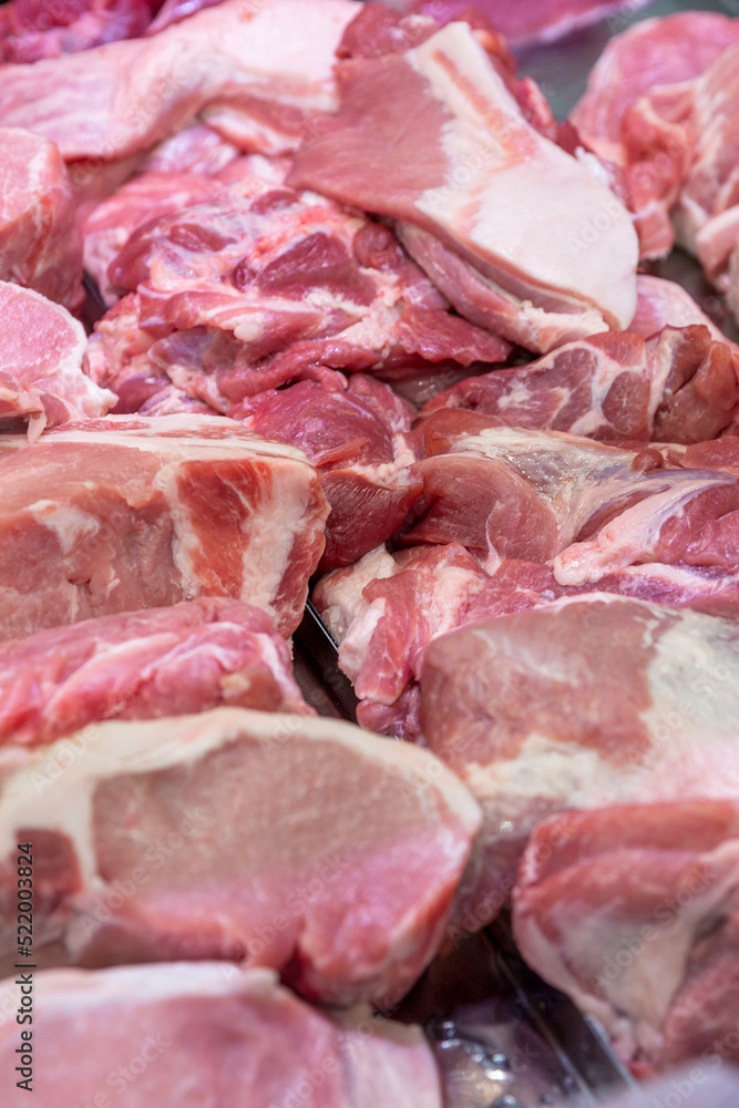Raw meat pieces on the counter in the store. Fresh semi-finished products. Close-up. Vertical.