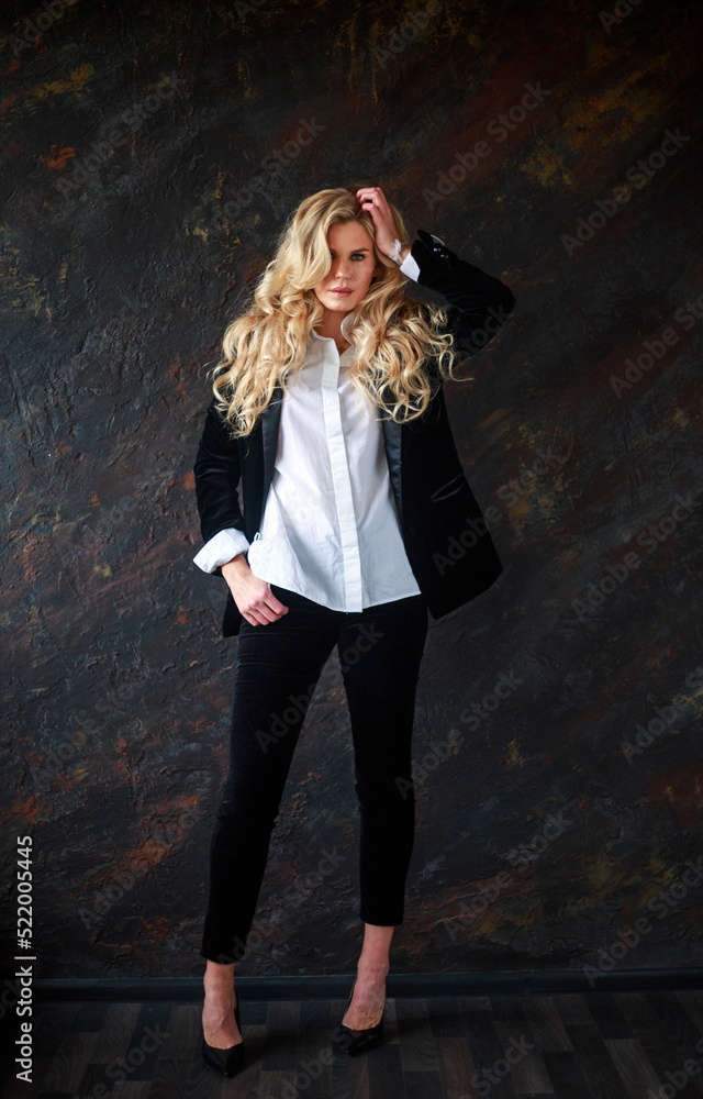 Gorgeous business lady in black suit and white shirt on black background, portrait of beautiful woman Gorgeous business lady in black suit and white shirt on black background, portrait of beautiful woman