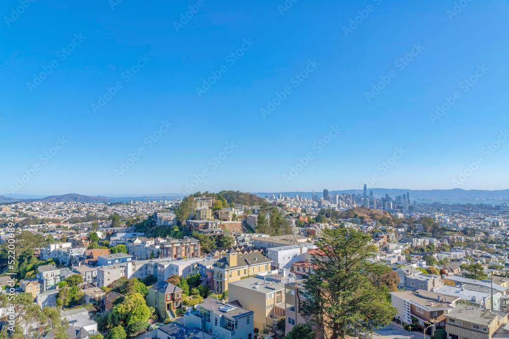 Dense apartment buildings and townhouses around the hill in the middle at San Francisco, CA