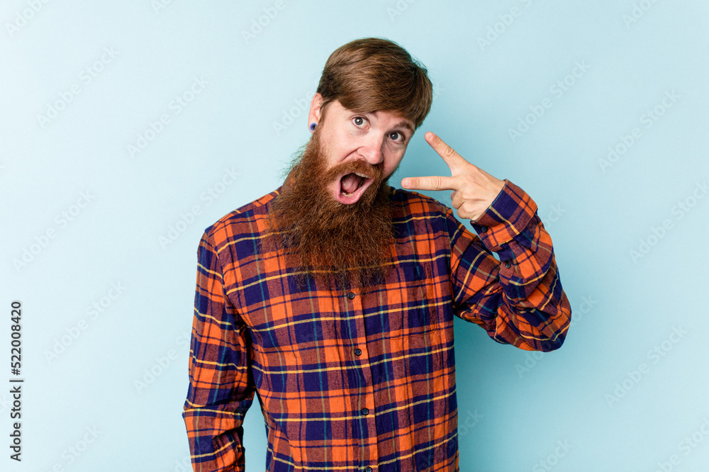 Young caucasian red-haired man isolated on blue background dancing and having fun. Young caucasian red-haired man isolated on blue background dancing and having fun.