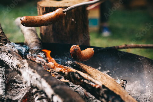 Sausages are fried on an open fire.