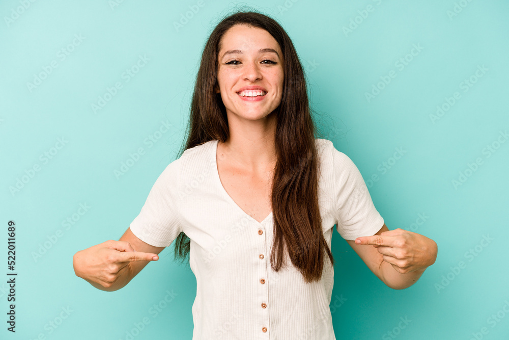Young caucasian woman isolated on blue background points down with fingers, positive feeling. Young caucasian woman isolated on blue background points down with fingers, positive feeling.