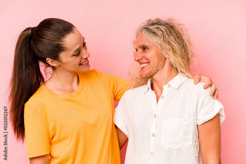 Caucasian mom and daughter isolated on pink background Caucasian mom and daughter isolated on pink background