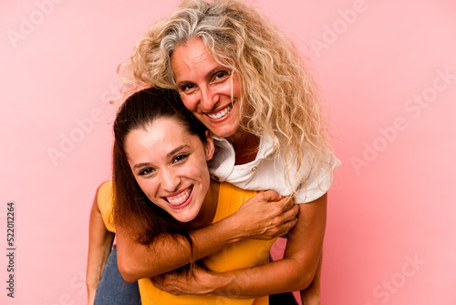 Caucasian mom and daughter isolated on pink background