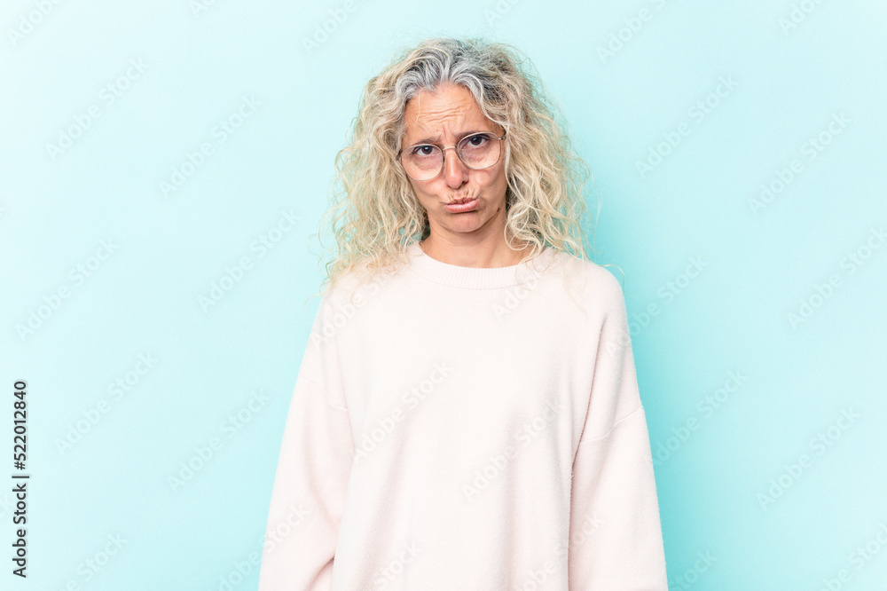 Middle age caucasian woman isolated on blue background sad, serious face, feeling miserable and displeased.