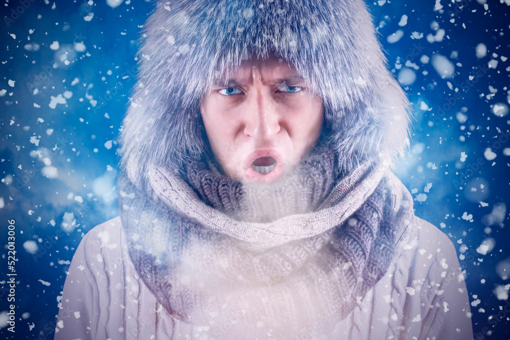 Isolate. Cold weather. Bask. A man in a fur hat and scarf warms his hands with his mouth. It's winter time Isolate. Cold weather. Bask. A man in a fur hat and scarf warms his hands with his mouth. It's winter time