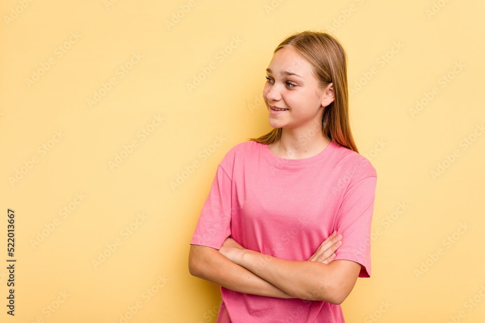 Young caucasian girl isolated on yellow background smiling confident with crossed arms.